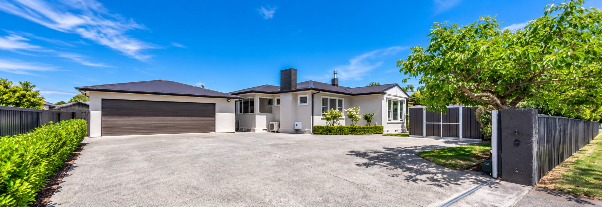 Residential concrete driveway outside a Christchurch-style home
